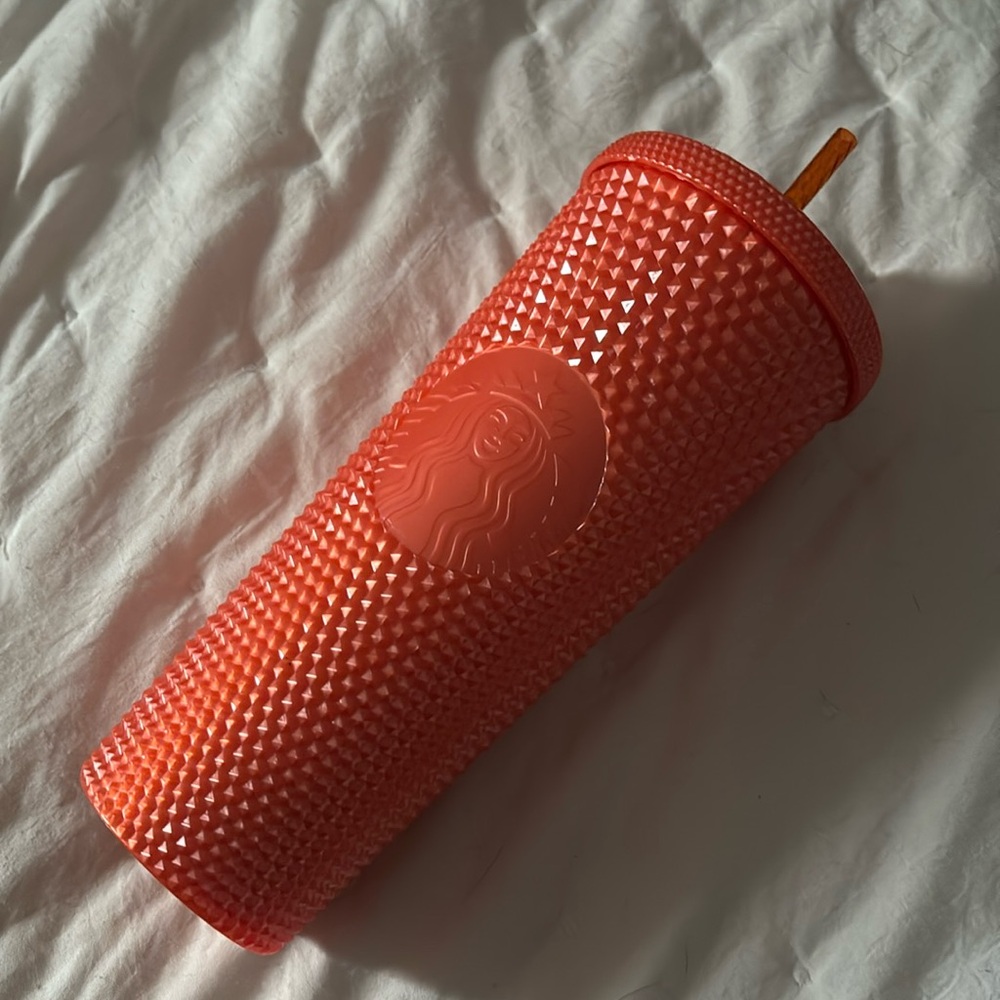 24oz orange studded Starbucks cup with straw.